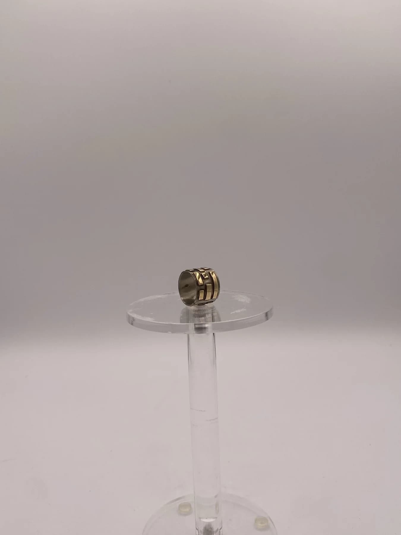 A small ring shown on a clear display stand.
