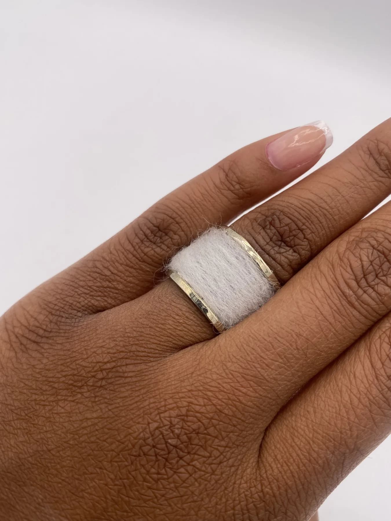 Wide band ring worn on a hand.